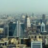 Modern skyscrapers dominate a sprawling cityscape under a hazy sky