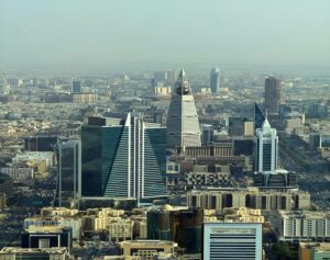 Modern skyscrapers dominate a sprawling cityscape under a hazy sky