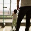 Father and daughter look out window