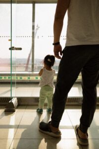 Father and daughter look out window