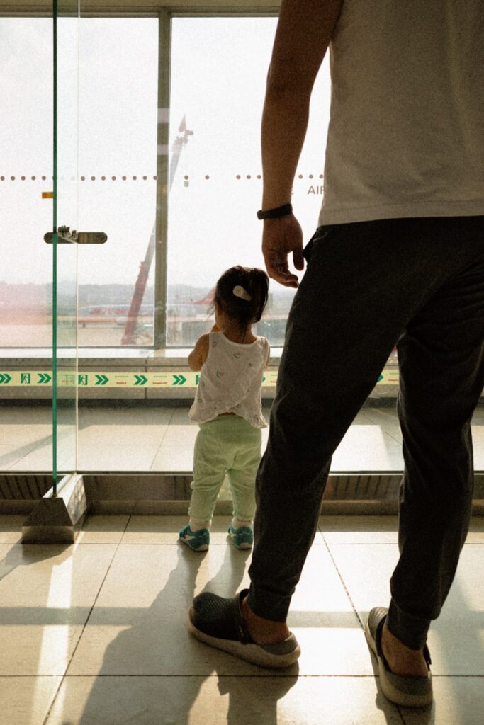 Father and daughter look out window